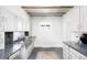 Bright kitchen features stone countertops, stainless steel appliances, and white cabinets at 4134 Bryant St, Denver, CO 80211
