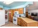 Open kitchen with tiled floor features natural wood cabinets, white appliances and seamless flow into other rooms at 750 S Dearborn Ct, Aurora, CO 80012