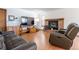 Bright living room featuring wood floors, brick fireplace, and comfortable leather seating at 750 S Dearborn Ct, Aurora, CO 80012