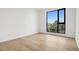 Cozy bedroom with wood floors and a large window overlooking city views at 1601 Park Ave # 506, Denver, CO 80218
