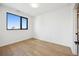 Minimalist bedroom with hardwood floors and a large window showcasing city views at 1601 Park Ave # 506, Denver, CO 80218