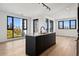 Modern kitchen with dark island, stainless appliances, and beautiful hardwood floors at 1601 Park Ave # 506, Denver, CO 80218