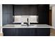 Contemporary kitchen featuring dark cabinets and an island with stone countertops and a black faucet at 1601 Park Ave # 506, Denver, CO 80218