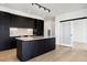 Modern kitchen with black cabinets, a quartz island, and hardwood floors with a sliding glass door at 1601 Park Ave # 506, Denver, CO 80218