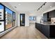 Open concept living room and kitchen with hardwood floors, black trim windows and modern black kitchen cabinets at 1601 Park Ave # 506, Denver, CO 80218