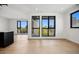 Bright living room with wood floors and expansive windows showcasing city views and access to a balcony at 1601 Park Ave # 506, Denver, CO 80218