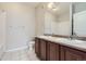 Bathroom featuring double sinks, a large mirror, and a combination shower/tub for functional everyday use at 4100 Albion St # 303, Denver, CO 80216