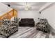 Basement living area features a ceiling fan, staircase, and comfortable seating arrangement at 2292 Brantner Pl, Brighton, CO 80601