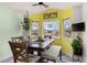 Cozy dining room featuring a rustic table, a ceiling fan, and sunny bay windows at 2292 Brantner Pl, Brighton, CO 80601