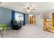 Comfortable living room featuring an accent wall, a ceiling fan, and a large window at 2292 Brantner Pl, Brighton, CO 80601