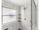 Updated bathroom with marble tile shower, glass door, shower head, shelving, and safety bars at 2292 Brantner Pl, Brighton, CO 80601