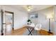 Bedroom with hardwood floors, ceiling fan, and writing desk with view to an adjacent bedroom at 3246 S Stuart St, Denver, CO 80236