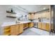 Bright kitchen showcasing modern floating shelves, undermount sink, and light-colored wood cabinets at 3246 S Stuart St, Denver, CO 80236