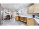 Sunlit kitchen and eat-in dining area with built in deskspace, pendant lighting and gray tile flooring at 3246 S Stuart St, Denver, CO 80236