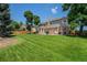 Spacious backyard featuring a well-maintained lawn, mature trees, and a patio area at 4541 Christensen Cir, Littleton, CO 80123