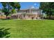 Expansive backyard with lush green lawn, mature trees, and a brick patio for outdoor entertaining at 4541 Christensen Cir, Littleton, CO 80123