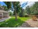 Lush backyard with mature trees and a well-manicured lawn, offering a serene outdoor space at 4541 Christensen Cir, Littleton, CO 80123
