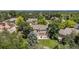 Aerial backyard view features a patio with seating, a well manicured lawn, mature trees, and a lovely home at 4541 Christensen Cir, Littleton, CO 80123