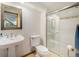 Bright, clean bathroom with white fixtures, glass-enclosed shower, and decorative mirror at 4541 Christensen Cir, Littleton, CO 80123