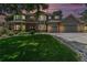 Charming two-story home boasts a well-manicured lawn, a three-car garage, and attractive brick accents at sunset at 4541 Christensen Cir, Littleton, CO 80123