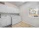 Bright laundry room features a washer, dryer, and ample storage cabinets above the sink at 4541 Christensen Cir, Littleton, CO 80123