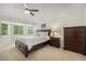Spacious main bedroom with a large bed, bay window, ceiling fan, and dresser at 4541 Christensen Cir, Littleton, CO 80123