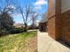 A lovely backyard with a mix of grass and concrete, plus a brick house with visible trees and sky at 9645 W 73Rd Pl, Arvada, CO 80005