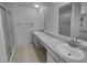 Bright bathroom with a double sink vanity, walk-in shower, and modern fixtures at 9645 W 73Rd Pl, Arvada, CO 80005