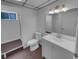 Updated bathroom features wood look flooring, a vanity with sink, and a window in the shower at 9645 W 73Rd Pl, Arvada, CO 80005