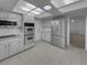 Well-lit kitchen boasts stainless steel appliances, white cabinets, and a tiled floor at 9645 W 73Rd Pl, Arvada, CO 80005