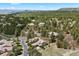 An aerial view of a neighborhood showcasing tree-lined streets, beautiful homes, and mountainous views at 5091 Hidden Pond Pl, Castle Rock, CO 80108