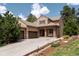 Inviting single-Gathering home featuring a stone archway, porch swing, 3-car garage, and tile roof at 5091 Hidden Pond Pl, Castle Rock, CO 80108
