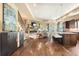 Open concept living space with hardwood floors, a stone fireplace, and a modern kitchen at 5091 Hidden Pond Pl, Castle Rock, CO 80108