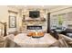 Warm living room with a stone fireplace, wooden mantel, and comfortable seating arrangements at 5091 Hidden Pond Pl, Castle Rock, CO 80108