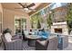 Relaxing outdoor patio with a stone fireplace, comfortable seating, and lush landscaping at 5091 Hidden Pond Pl, Castle Rock, CO 80108