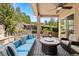 Inviting covered patio with comfortable seating, a ceiling fan, and a stone waterfall feature at 5091 Hidden Pond Pl, Castle Rock, CO 80108