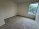 Bright bedroom with neutral carpeting and natural light from a large window at 12166 Melody Dr # 202, Denver, CO 80234