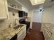 Charming kitchen features granite countertops, white cabinets, and a modern stainless steel microwave at 12166 Melody Dr # 202, Denver, CO 80234