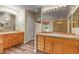 Bathroom with dual vanities, wood cabinets, and a separate shower at 6533 S Ouray St, Aurora, CO 80016