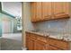 Butler pantry featuring granite counters, mosaic tile backsplash, and custom cabinetry at 6533 S Ouray St, Aurora, CO 80016