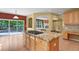 Kitchen island with granite cooktop, custom cabinets, and views to the backyard and fireplace at 6533 S Ouray St, Aurora, CO 80016