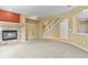 Spacious living room featuring a cozy fireplace, neutral carpet and an open staircase at 6533 S Ouray St, Aurora, CO 80016