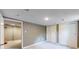 Spacious basement featuring neutral carpet, lighting, and access to additional rooms at 9075 W 66Th Ave, Arvada, CO 80004