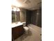 Well-lit bathroom features a shower-tub combo, dark tile, and mosaic accents at 9075 W 66Th Ave, Arvada, CO 80004