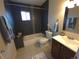 Well-lit bathroom featuring a tub, shower and modern grey tile, complimented by a vanity at 9075 W 66Th Ave, Arvada, CO 80004
