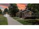 Charming home featuring a detached garage and cozy front deck, illuminated by warm light at 9075 W 66Th Ave, Arvada, CO 80004