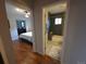 Hallway showcasing a bedroom with ceiling fan and bathroom with modern grey tile in shower area at 9075 W 66Th Ave, Arvada, CO 80004