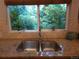 Bright kitchen sink area featuring a double sink, granite countertops, and a picturesque window view at 9075 W 66Th Ave, Arvada, CO 80004