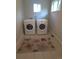 Bright laundry room with two modern, white, front-load washing machines at 9075 W 66Th Ave, Arvada, CO 80004