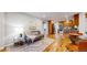 Open-concept living room seamlessly connects to the kitchen, featuring hardwood floors and modern decor at 9075 W 66Th Ave, Arvada, CO 80004